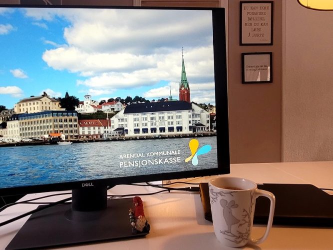 En pc skjerm med bilde av Arendal med Arendal kommunale pensjonkasse logo på.